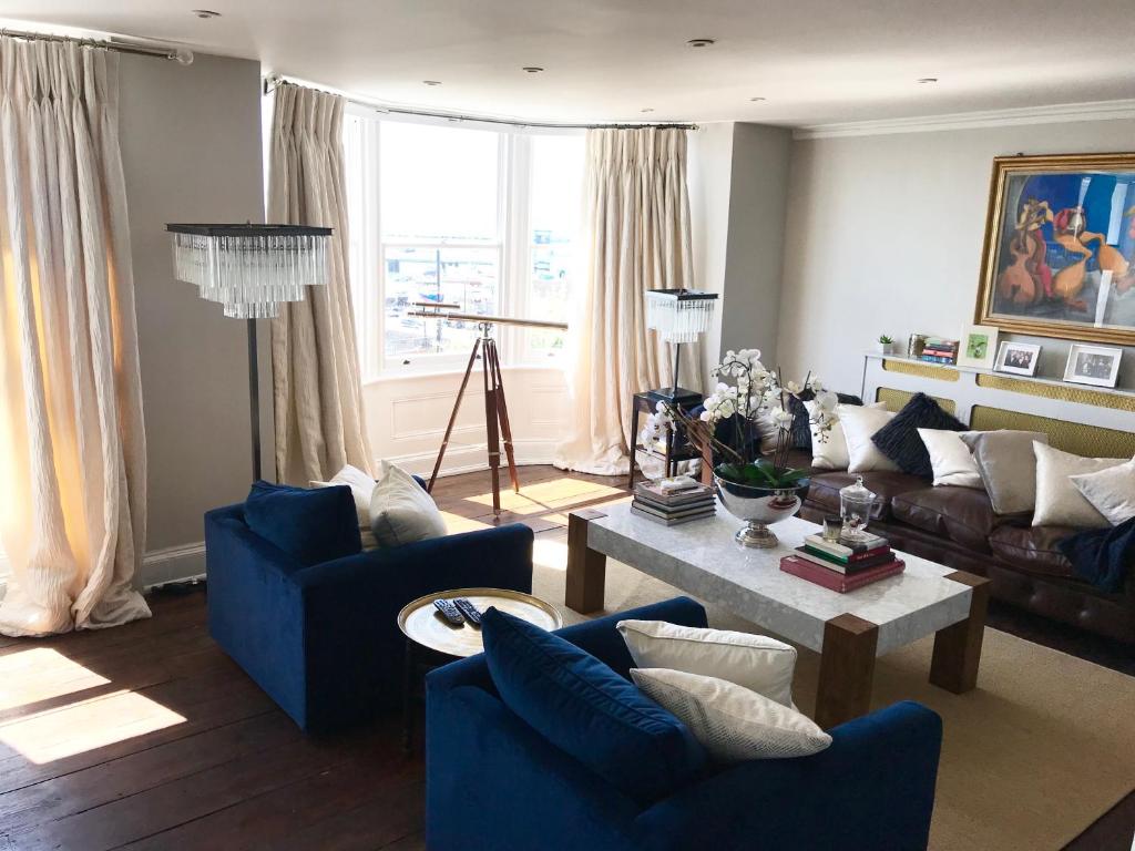 拉姆斯蓋特的住宿－Marina Retreat - Stunning 4 bedroom, 3 bathroom house with harbour views!，客厅配有蓝色的沙发和桌子