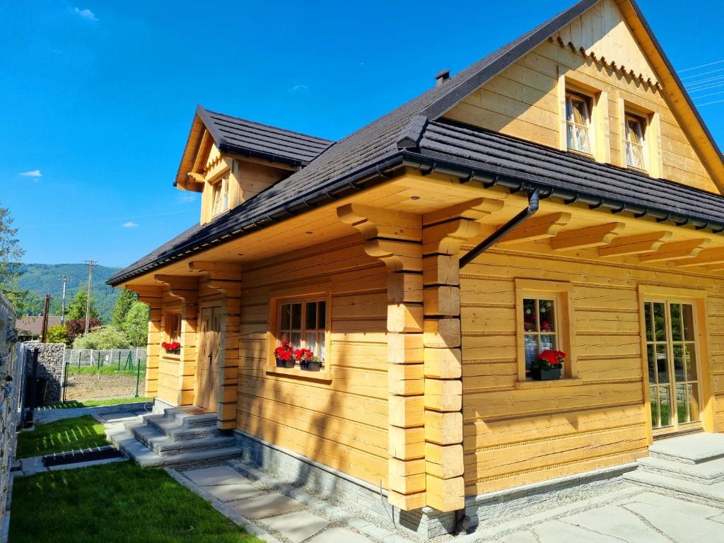 uma cabana de madeira com janelas e um telhado em Złoty Dom Brenna em Brenna