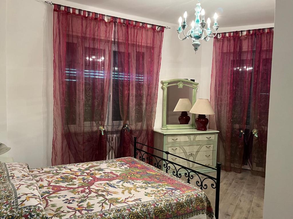 1 dormitorio con cama, tocador y espejo en Paradiso del Relax, en Alessandria