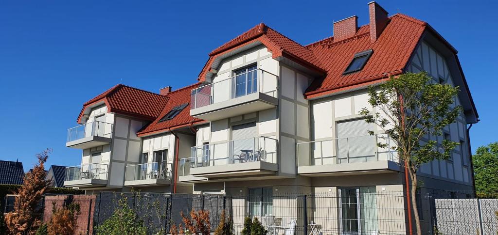 a large building with a red roof at Apartamenty Wrzosowa in Dębki