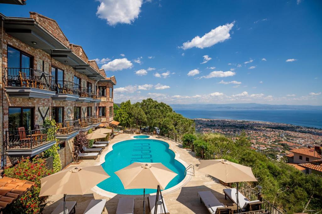 - une vue sur un hôtel doté d'une piscine et de parasols dans l'établissement Papazlıkhan Hotel, à Altınoluk