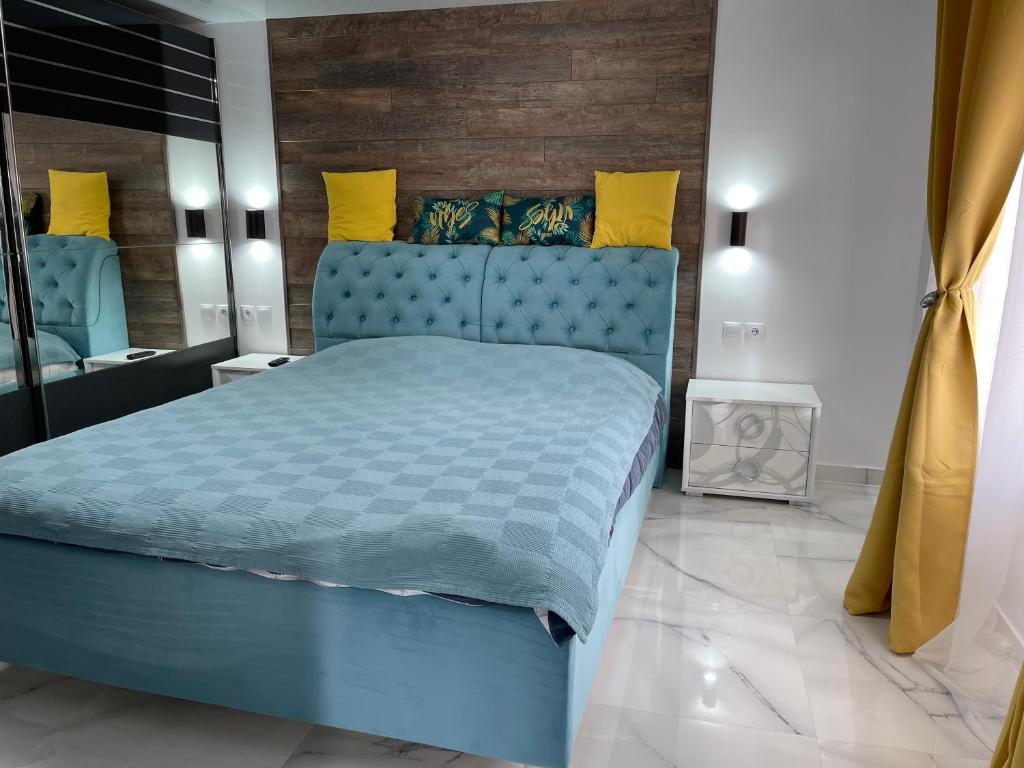 una camera con letto blu e specchio di Casuta din livada a Botoşani