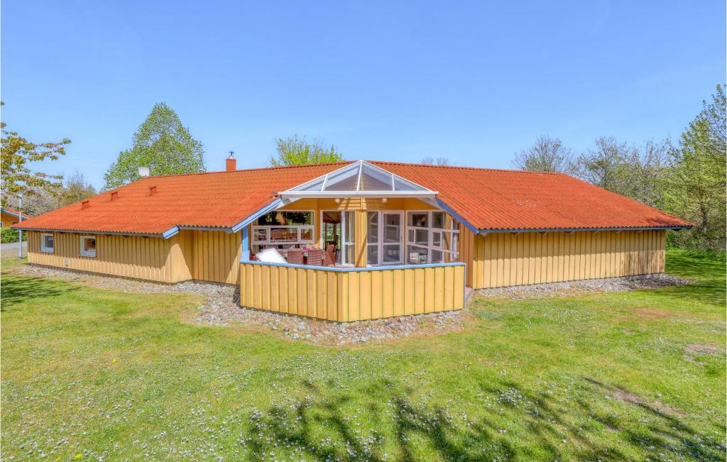 a house with an orange roof on a grass field at Poolhaus 2 In Hohendorf in Hohendorf