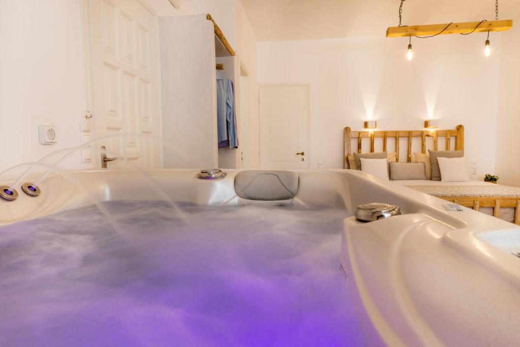 y baño con bañera llena de agua púrpura. en Aqua Naxos Apartments & Suites en Naxos