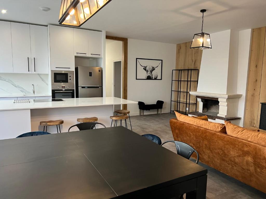 uma cozinha e sala de estar com uma mesa e um sofá em Loft ravissant entre terre et mer em Lanvollon