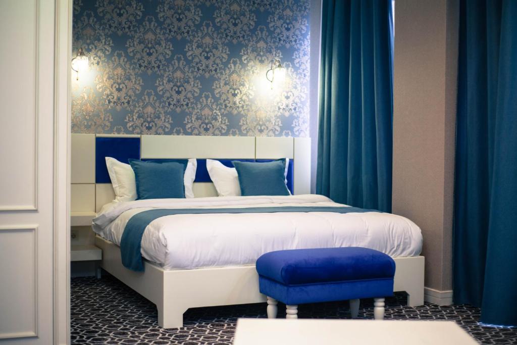 a bedroom with a bed with blue walls and blue curtains at Park Hotel in Qyzylorda