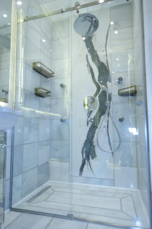 een douche met een glazen deur in de badkamer bij AB Residences -Cihangir Luxury Antique Apartment in Istanbul