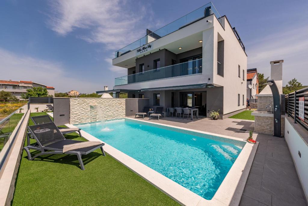 uma villa com uma piscina e uma casa em Villa Blue Sky 2 em Turanj