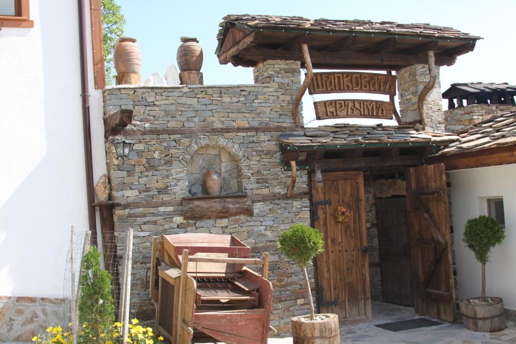 um edifício de pedra com um forno exterior num quintal em Guest House Shapkova Kushta em Delchevo