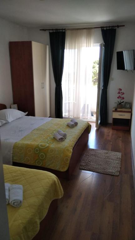 a hotel room with two beds and a large window at Apartman Mare in Drvenik