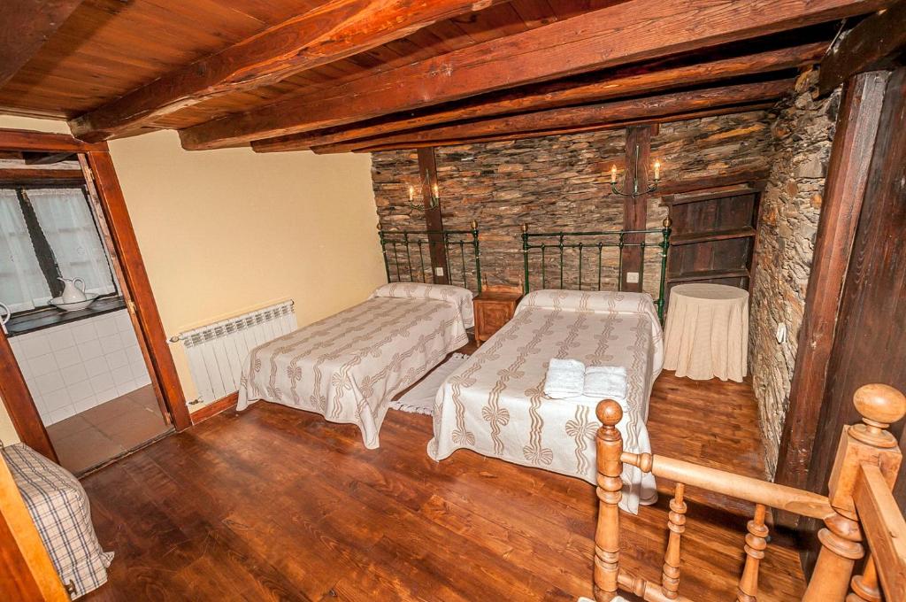 a bedroom with two beds in a log cabin at Casa Do Concello in Arnado