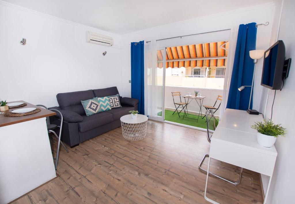 uma sala de estar com um sofá e uma mesa em Cosy Apartment Close to Sea, WiFi, Air Cond em Calpe
