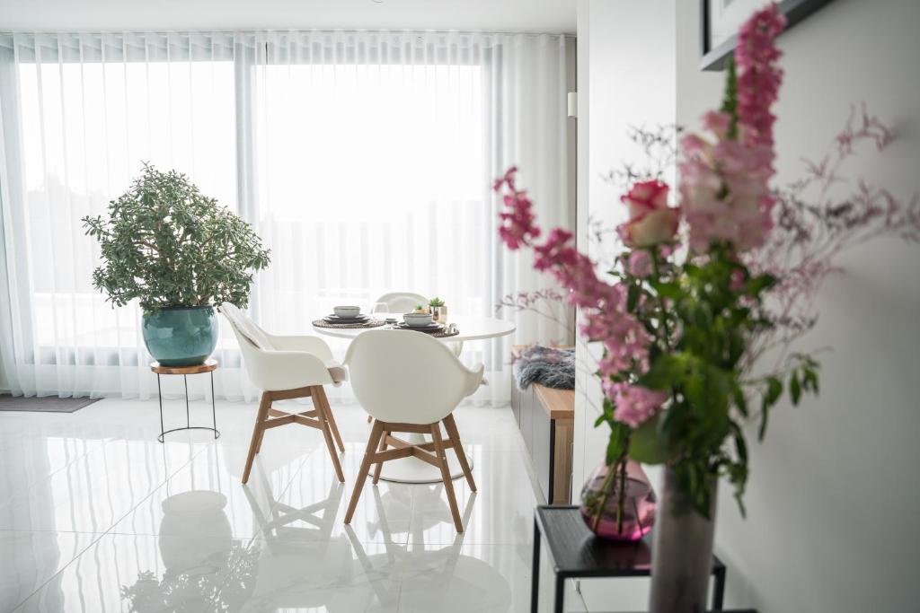 a living room with chairs and a table with flowers at Blue Yvey Apartment in Torhout