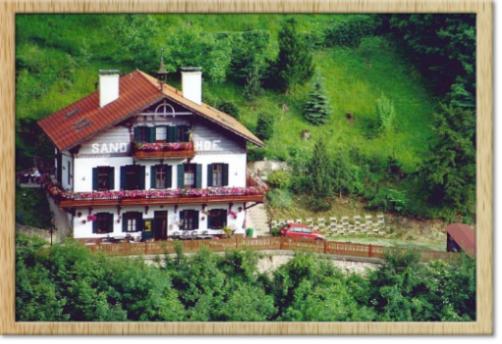 une grande maison blanche avec un toit rouge sur une colline dans l'établissement Sand-Hof, 