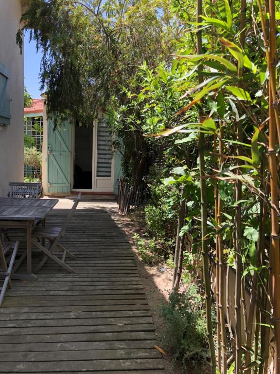 une passerelle en bois menant à une maison avec une table en bois dans l'établissement studio avec terrasse et jardin à 3 minutes à pied de la plage, à Canet