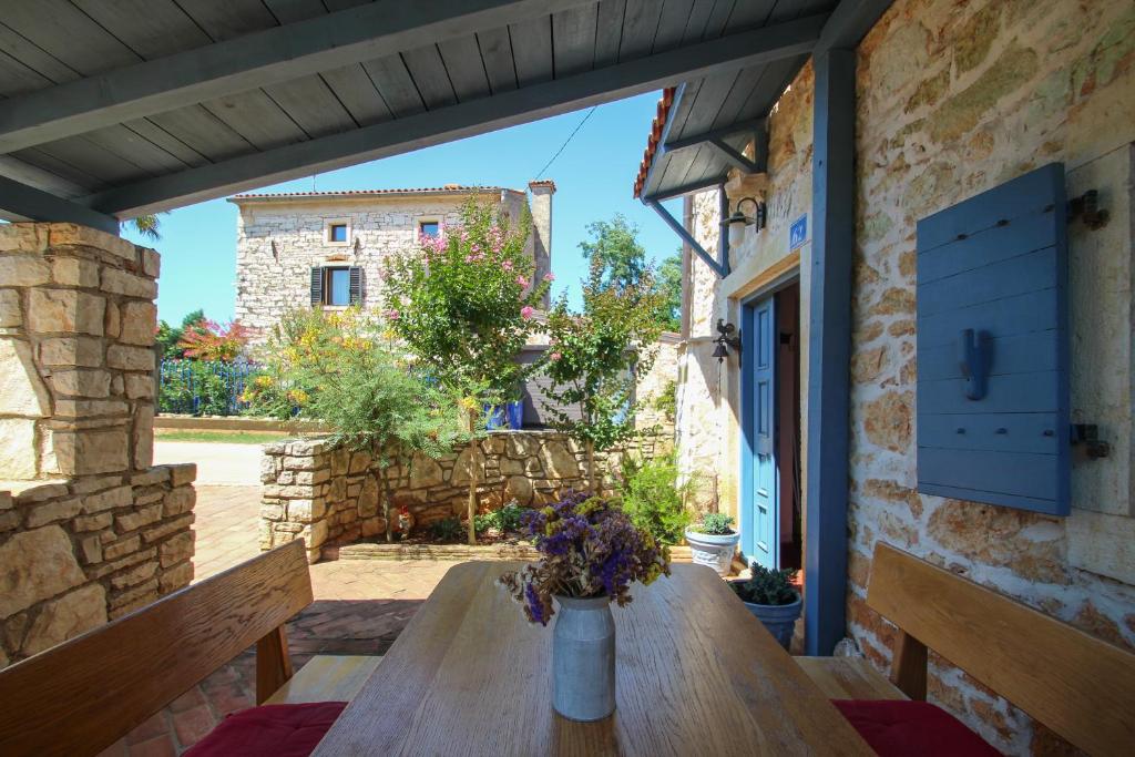 a wooden table with a vase of flowers on a patio at Casa Daniela in Babići