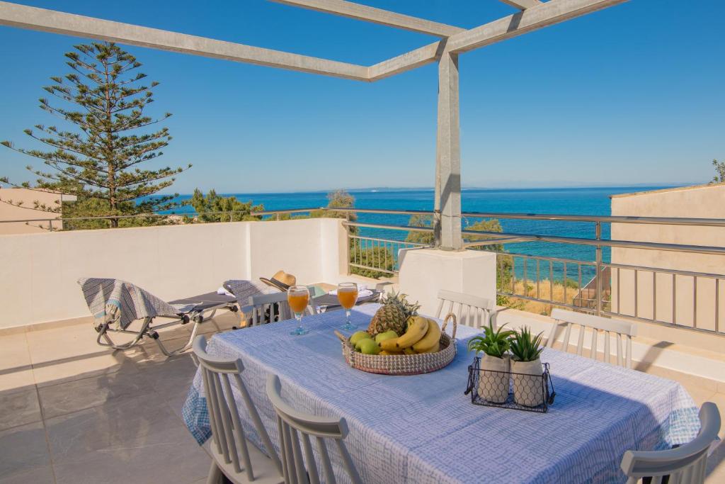 een tafel met een blauw tafelkleed en fruit op een balkon bij Emyria-Two-Floor Apartment with roof terrace in Zakynthos