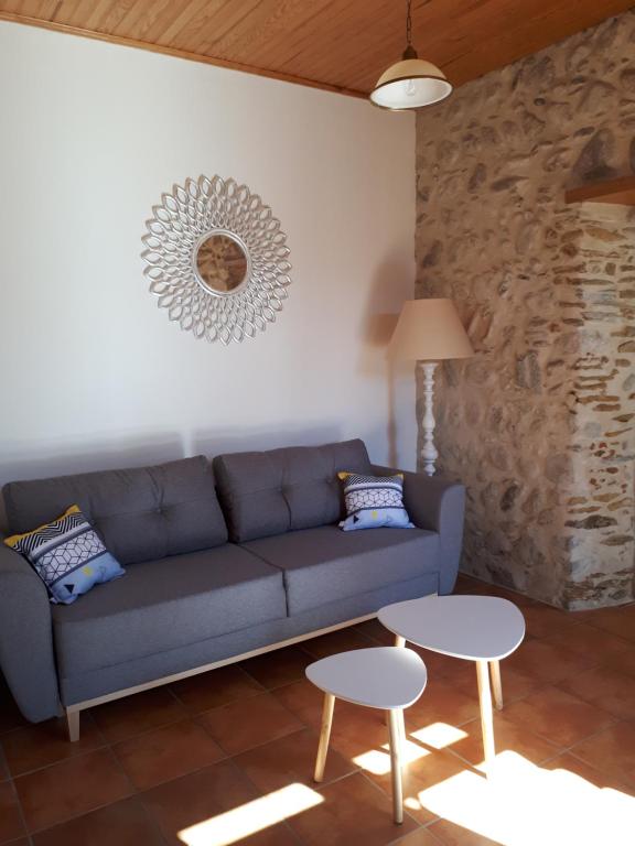 a living room with a blue couch and two tables at Bel appartement rénové dans maison bigourdane in Pouzac