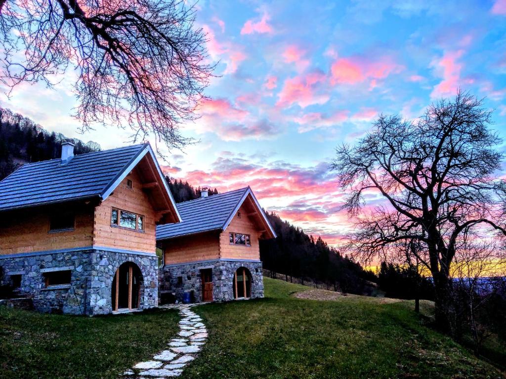 a house on a hill with a sunset in the background at Granaries Pear & Walnut in Tolmin