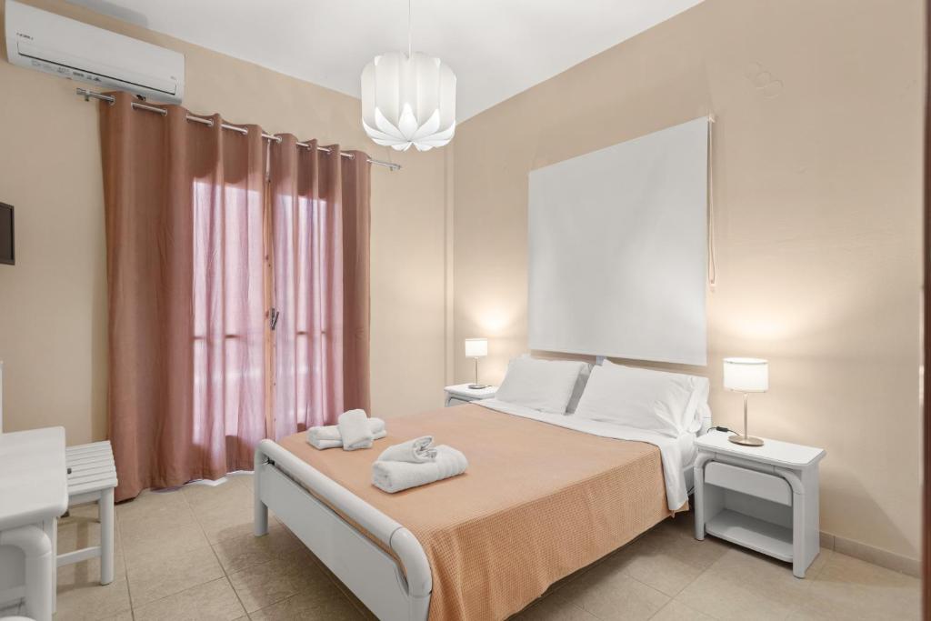 a bedroom with a bed with two towels on it at Dimitra's Studios in Stoupa