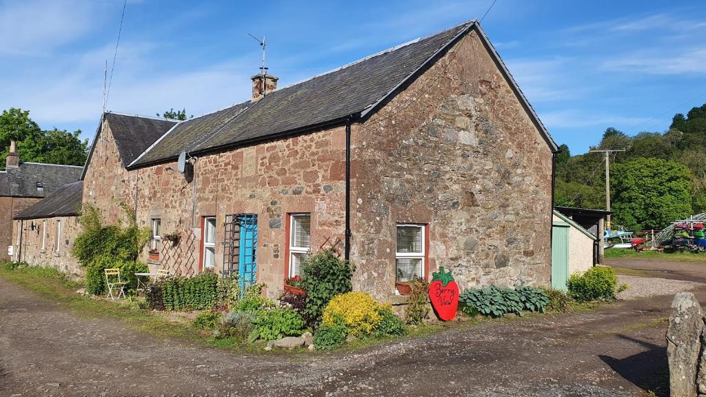 un vecchio edificio in pietra con graffiti blu sopra di Berry View - Idyllic cosy cottage on berry farm a Blairgowrie