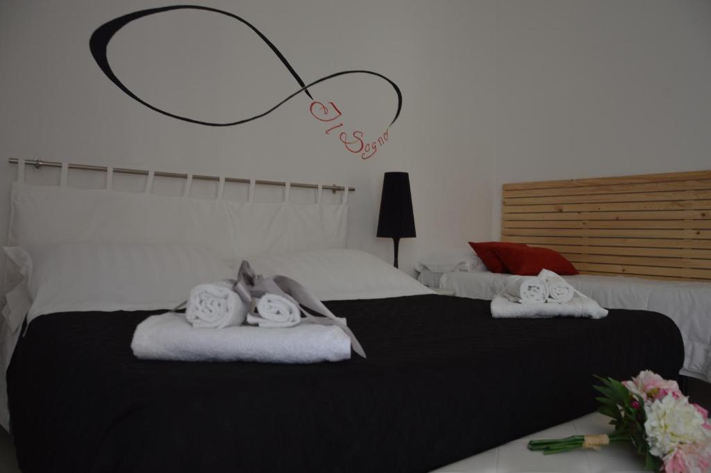 a bedroom with two beds with towels and a heart sign at Il Sogno Caltagirone in Caltagirone