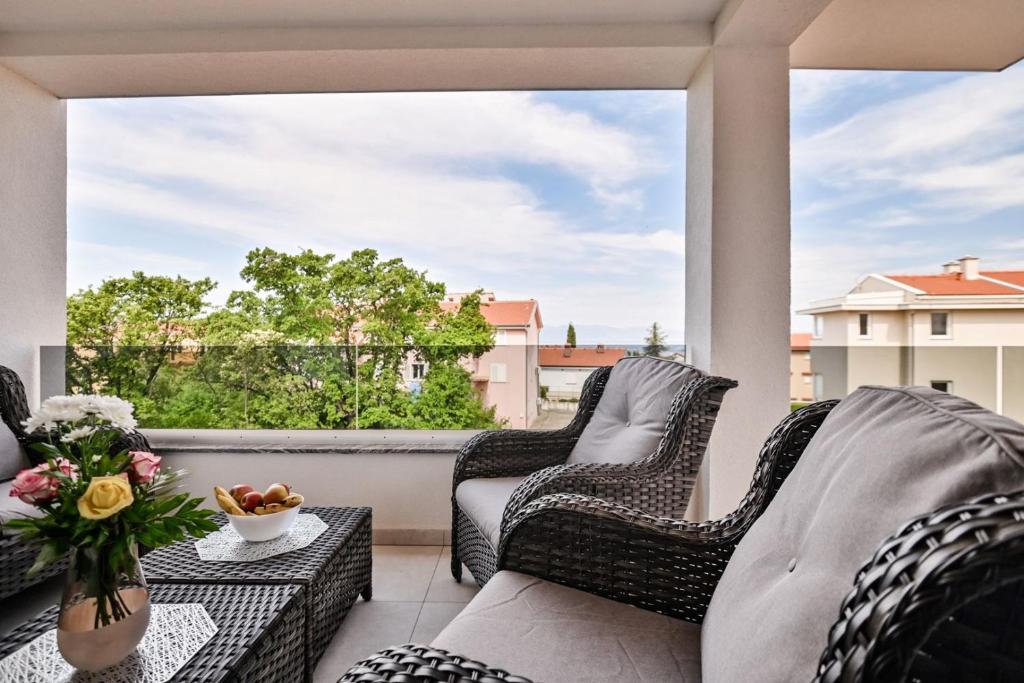 a balcony with wicker chairs and a large window at Luxury Apartment Nina with sea view in Sveti Anton