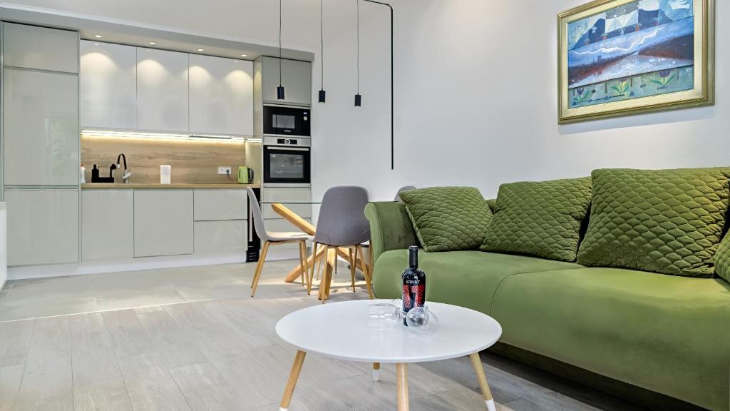 a living room with a green couch and a table at Apartman Nostra 1 in Zagreb