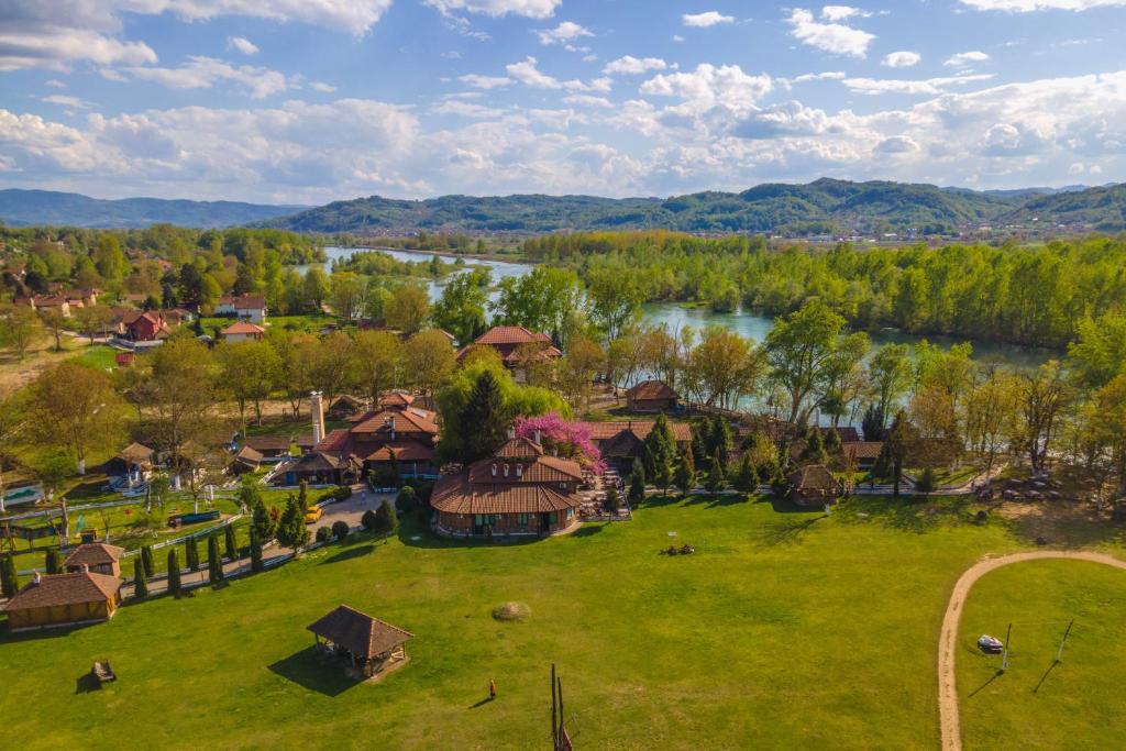 ein Luftblick auf ein Dorf mit Fluss und Bäumen in der Unterkunft B&B Etno Village Sunčana Reka in Banja Koviljača