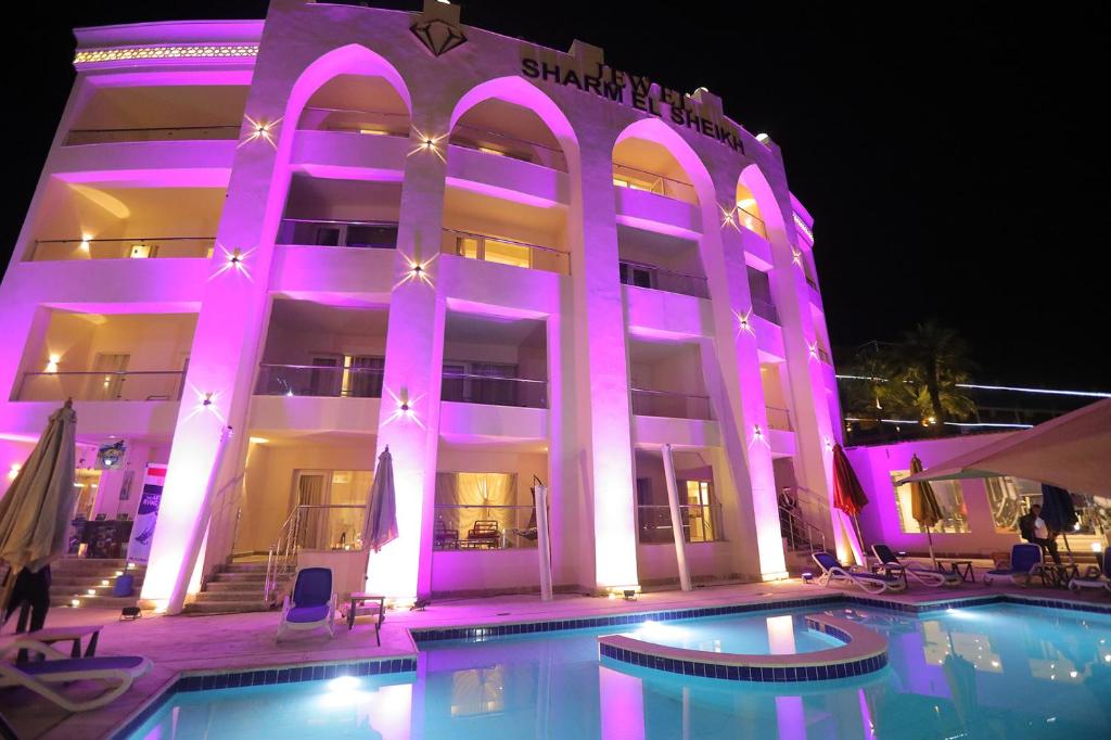 un edificio con una piscina di fronte ad essa di notte di Jewel Sharm El Sheikh Hotel a Sharm El Sheikh