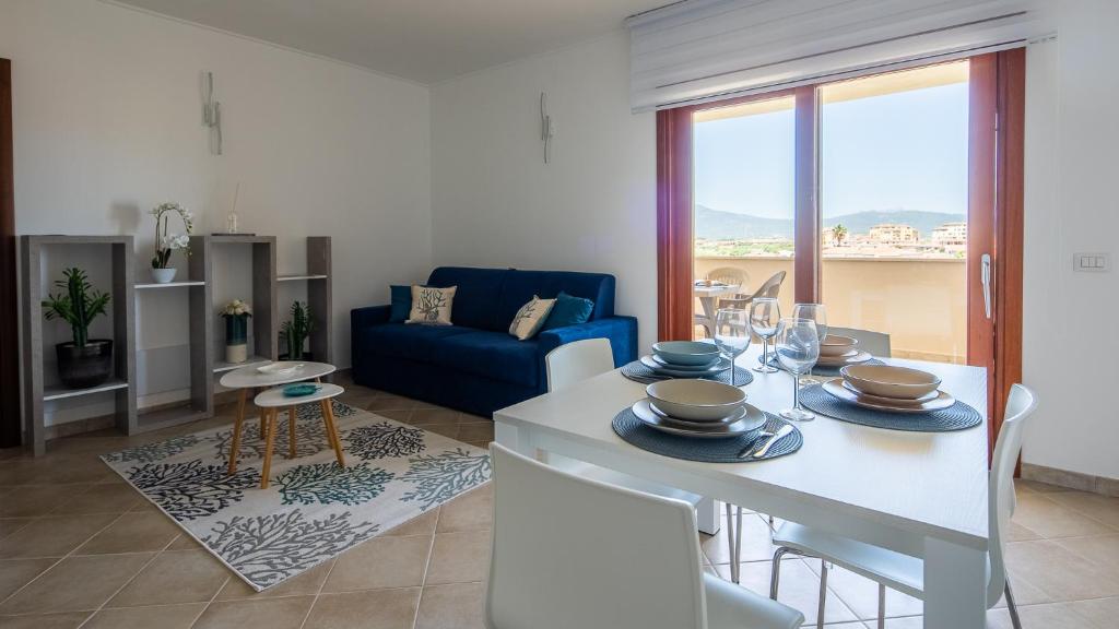 un soggiorno con tavolo e divano blu di Welcomely - Xenia Boutique House a Olbia