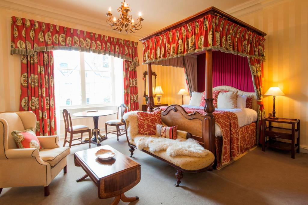 a bedroom with a canopy bed and a living room at Luttrell Arms in Dunster