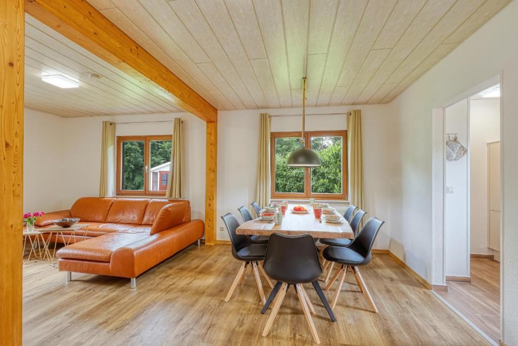 a living room with a table and chairs and a couch at Waldblick mit eigener Sauna in Kirchheim