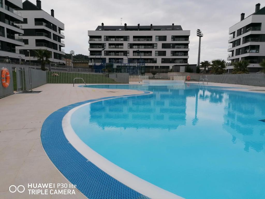 an empty swimming pool with buildings in the background at Luminoso Apartamento en Circulo Miramar in Luanco
