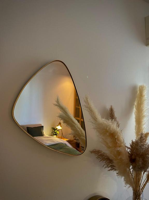 a mirror on a wall with a lamp and a plant at Maï Homes - La Villa Bompard in Marseille