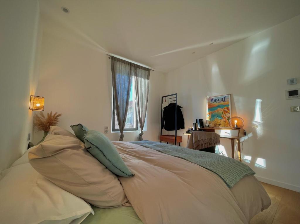 - une chambre avec un lit doté d'oreillers et d'une fenêtre dans l'établissement Maï Homes - La Villa Bompard, à Marseille