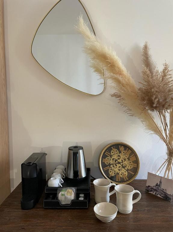 a table with a coffee maker and cups and a mirror at Maï Homes - La Villa Bompard in Marseille