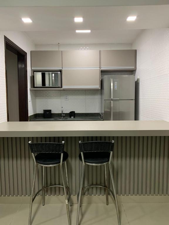 a kitchen with two bar stools at a counter at PALLADIUM APART SERVICE in São Vicente