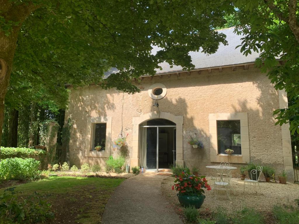 un edificio de ladrillo con una puerta y un patio en The Stables Gite at Chateau Mas de Pradié, en Foissac