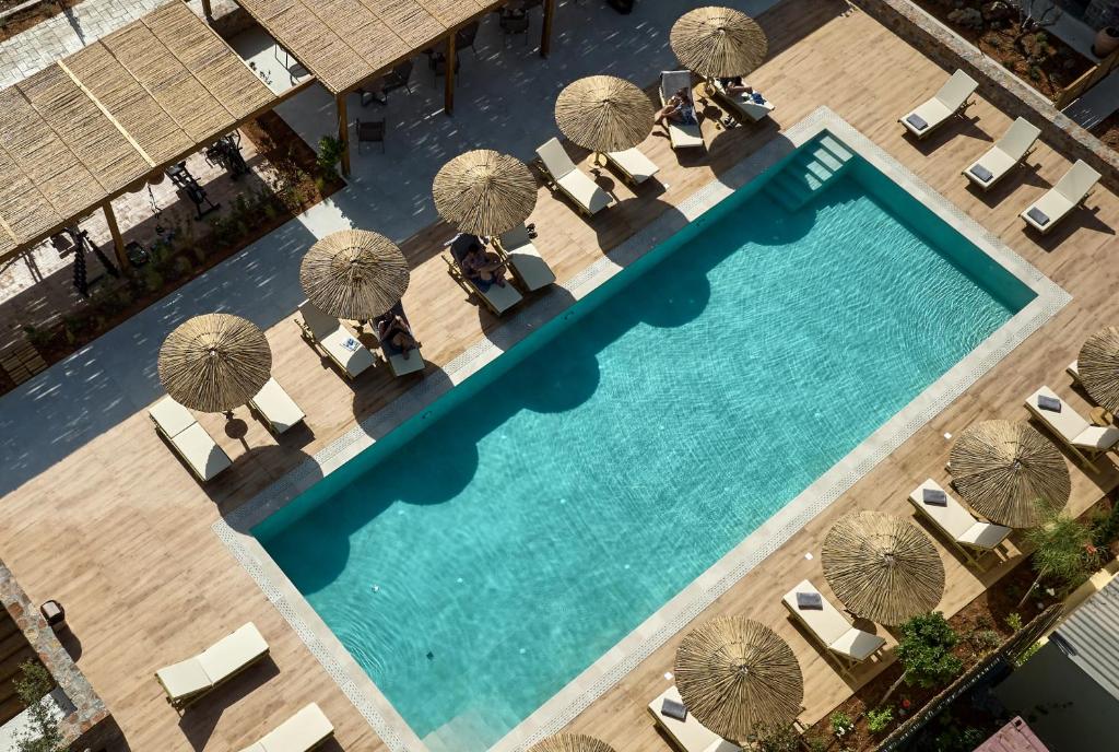 uma vista superior para uma piscina com guarda-sóis e cadeiras em Volta Suites and Villas em Gouves