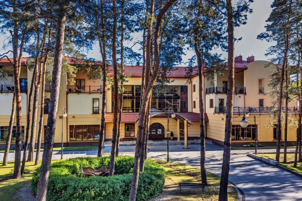 a building with trees in front of it at Hotel Pan Tadeusz in Serock