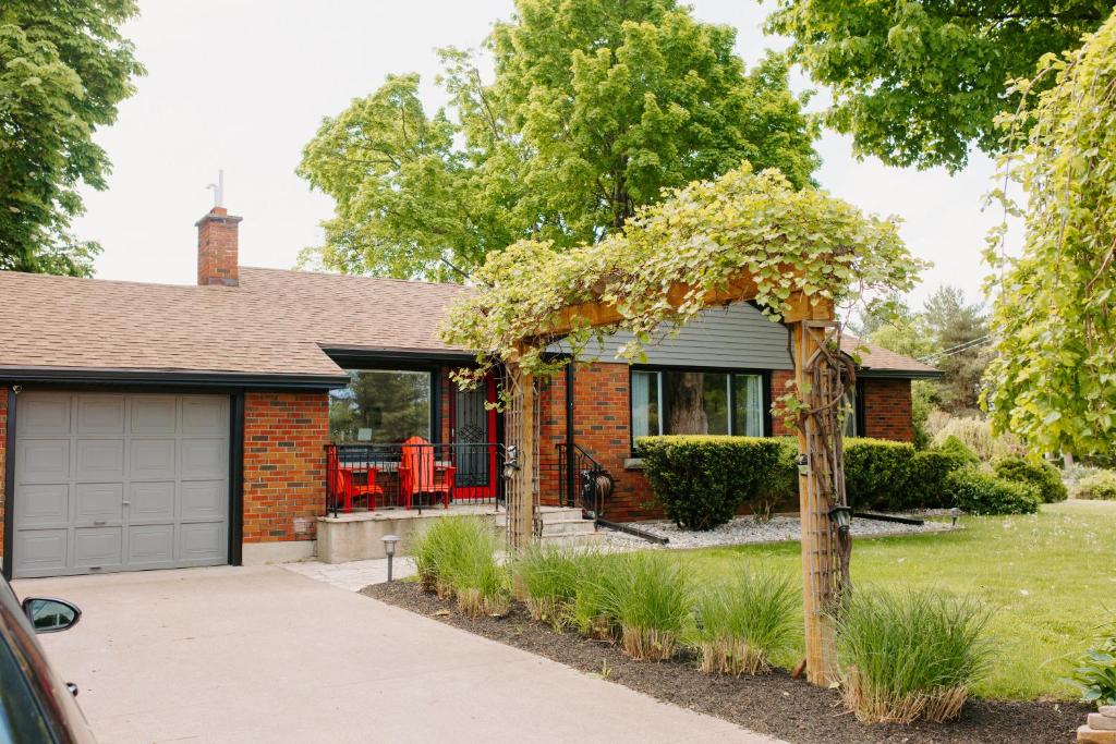 a red brick house with a garage at By The Vines in Niagara-on-the-Lake