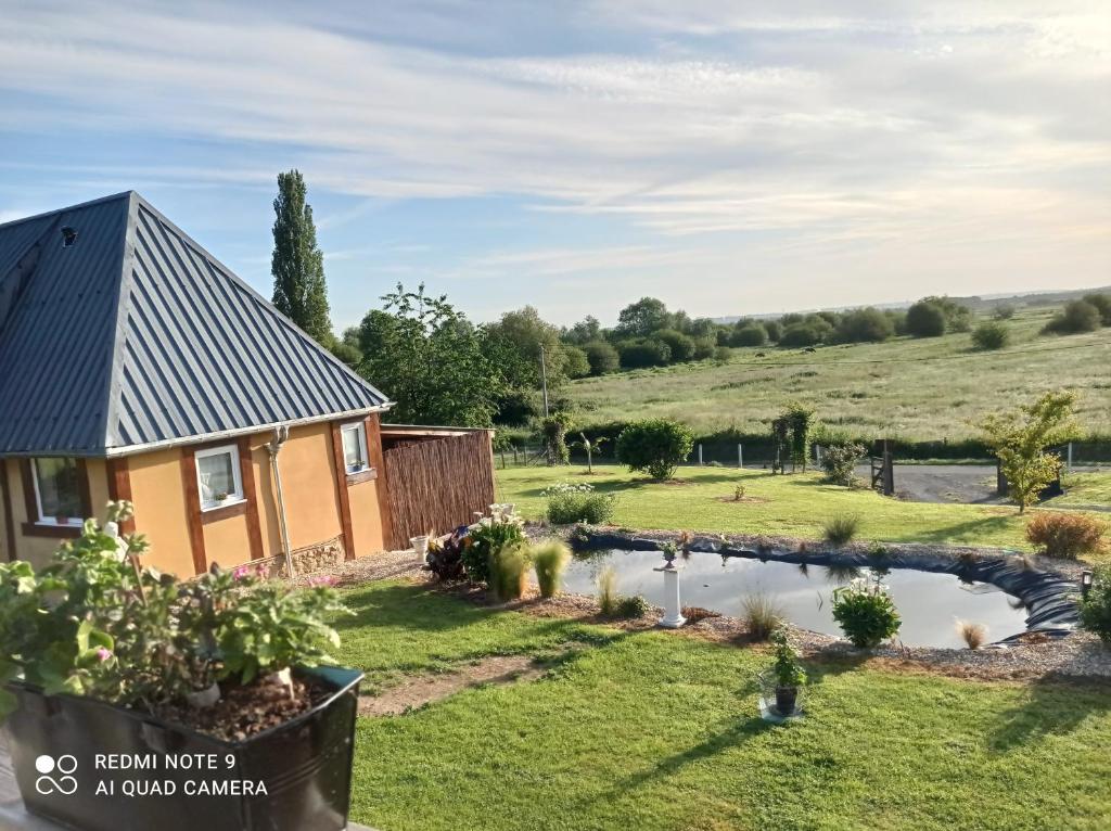 dom ze stawem na podwórku w obiekcie Gîte du roy w mieście Marais-Vernier