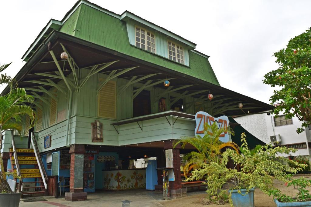 een groen gebouw met een groen dak bij Zus&Zo in Paramaribo