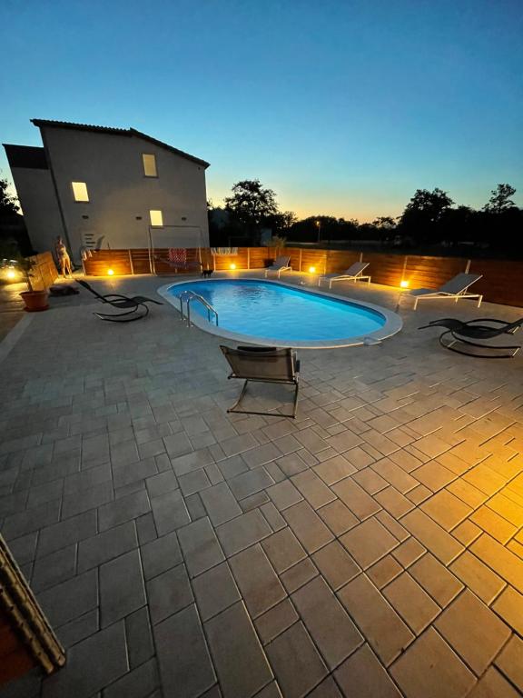 a large swimming pool with chairs around it at Holiday home “MARKO” with heated pool! in Nin