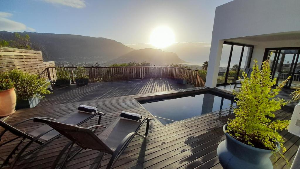una terraza con sillas y una piscina en una casa en Luxury Modern House Western Cape Fish Hoek, en Ciudad del Cabo