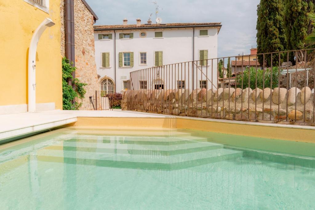 a swimming pool in front of a house at Residence Corte San Carlo in Colà di Lazise