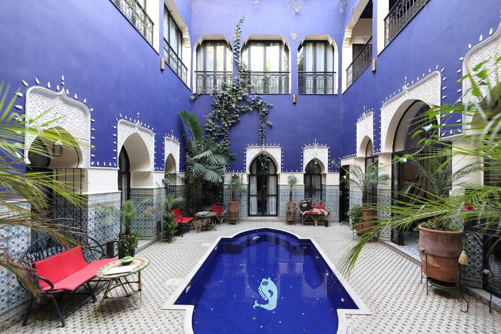 Riad Bindoo & Spa في مراكش: ساحة مع مسبح في مبنى به نباتات