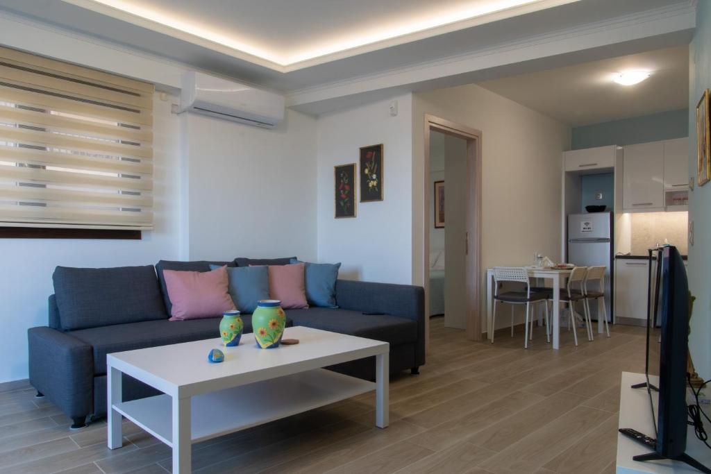 a living room with a blue couch and a table at Chelidoni apartment ground floor in Heraklio Town