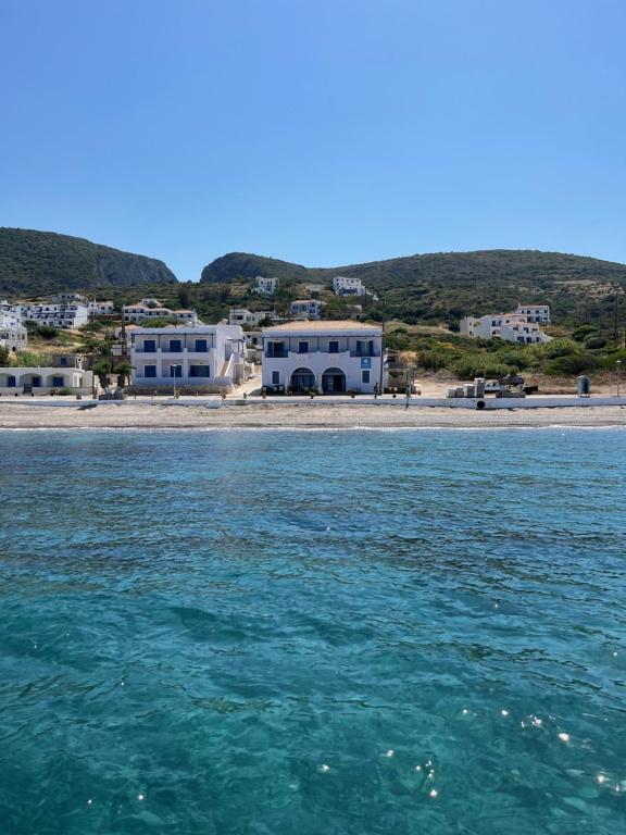 a view from the water of a beach with white buildings at Anesis Hotel in Agia Pelagia Kythira